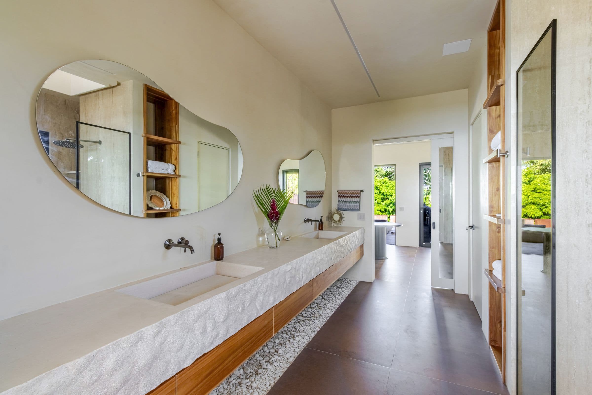 Bathroom with a sculpted double vanity and free-form mirrors