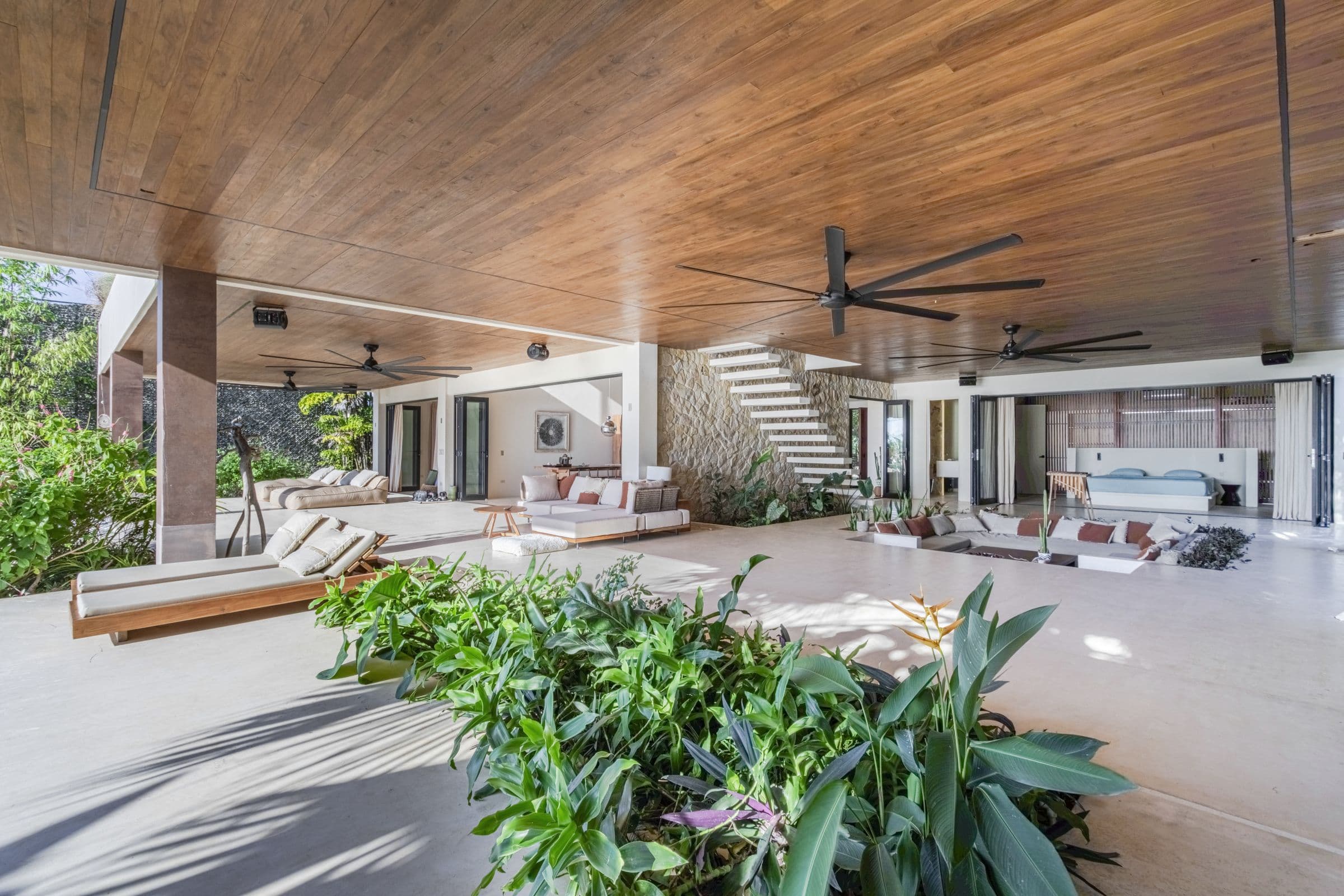 Covered outdoor living terrace with daybeds, planters and several lounge areas