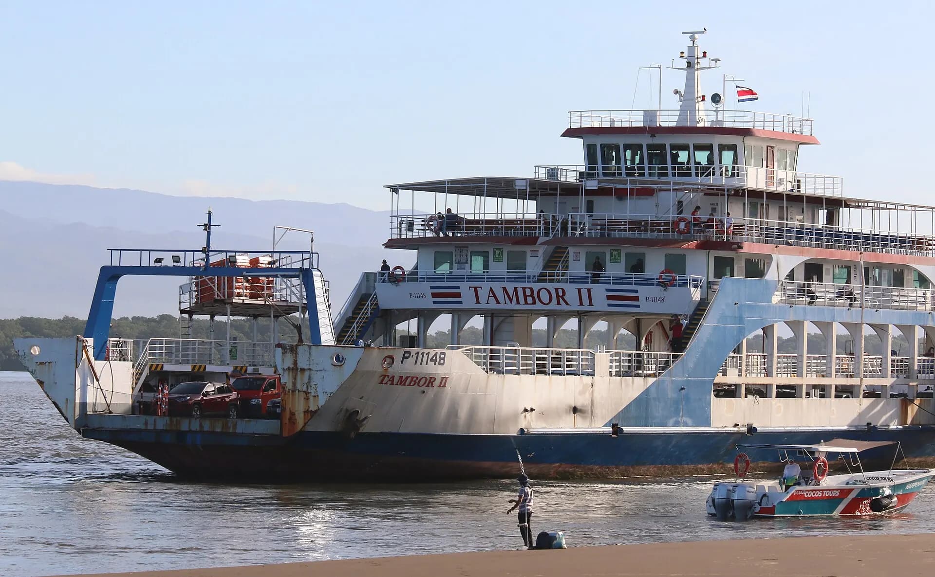 The Tambor II vehicle ferry passes a small boat near the Puntarenas waterfront.