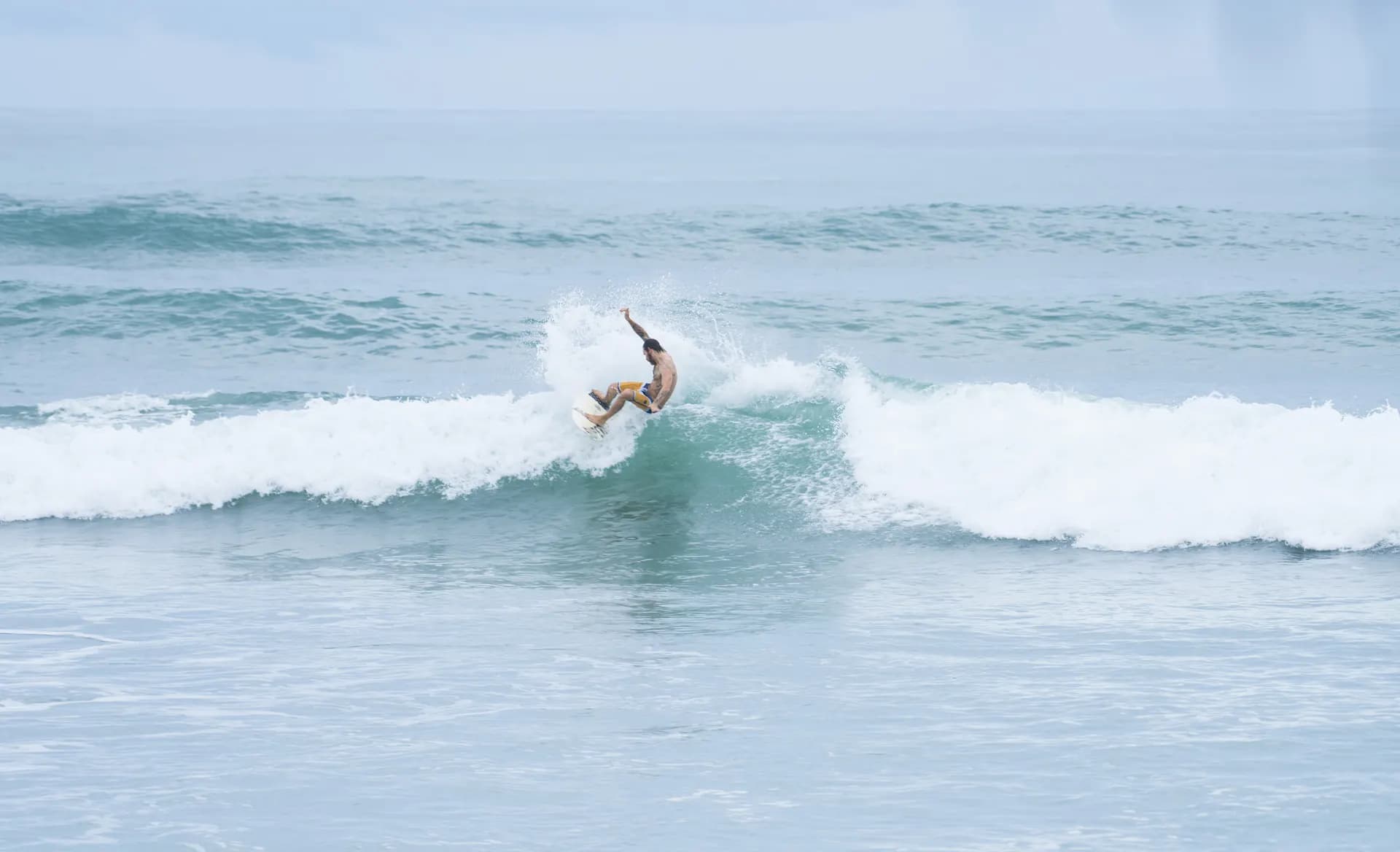 A surfer turns across a breaking wave at Playa Carmen in Costa Rica.