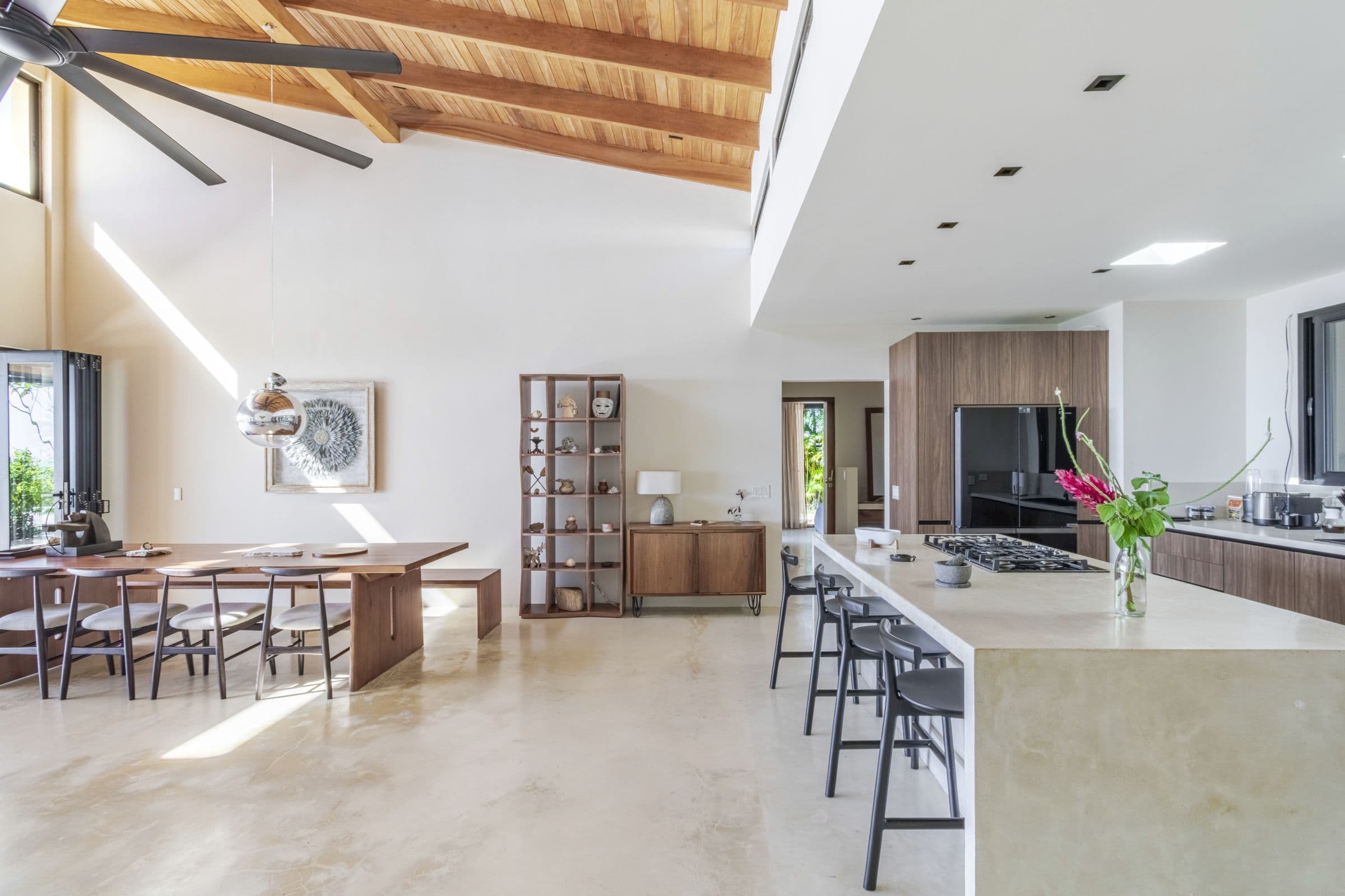 Kitchen island with gas cooktop and bar seating opening onto the dining area
