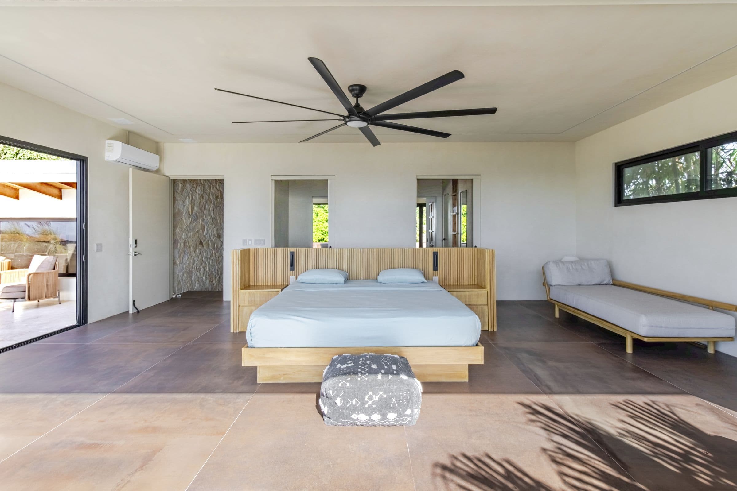 Upper-floor bedroom with a king bed, daybed, air conditioning and large ceiling fan