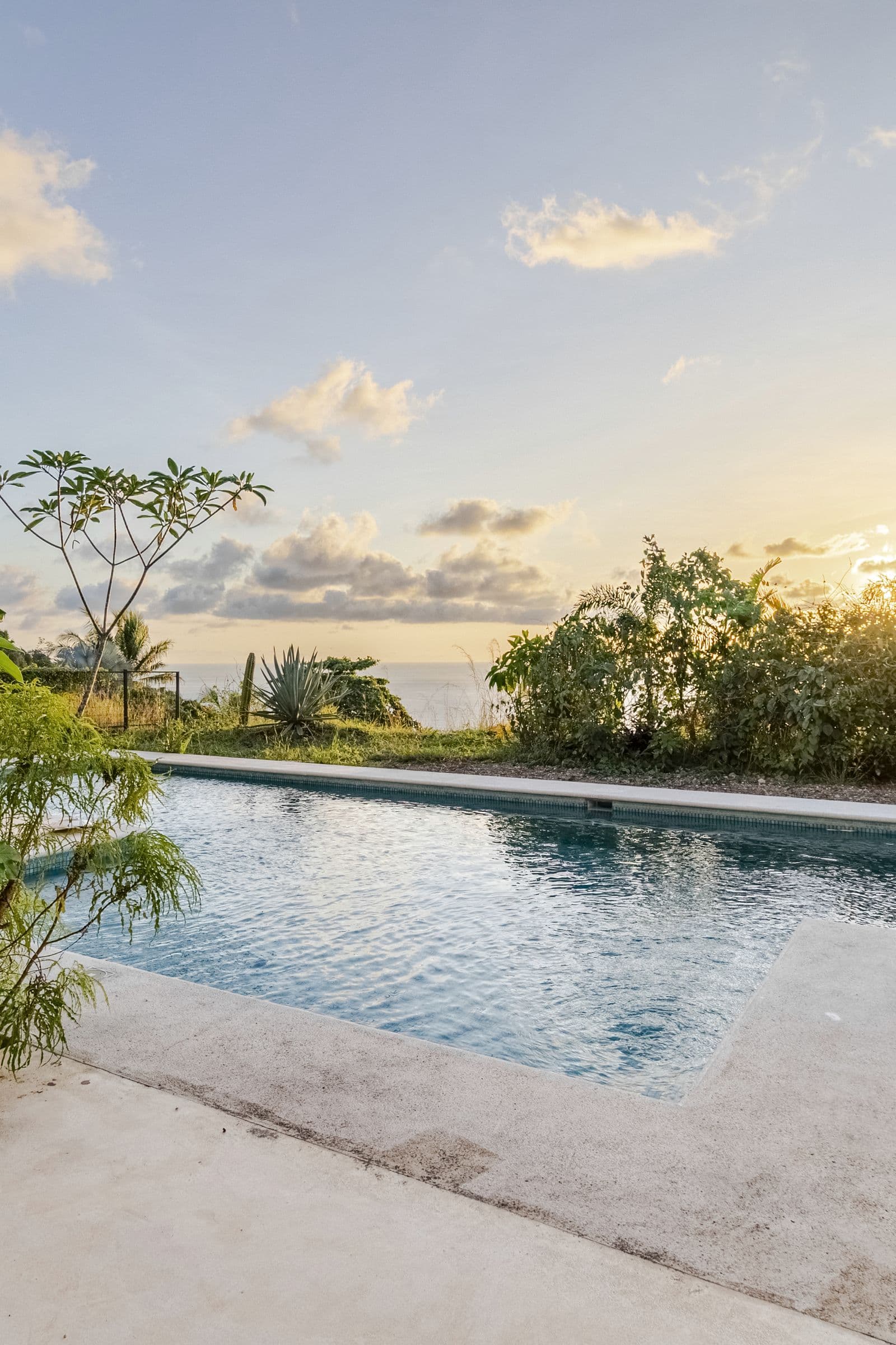 Swimming pool at sunset with the Pacific Ocean on the horizon