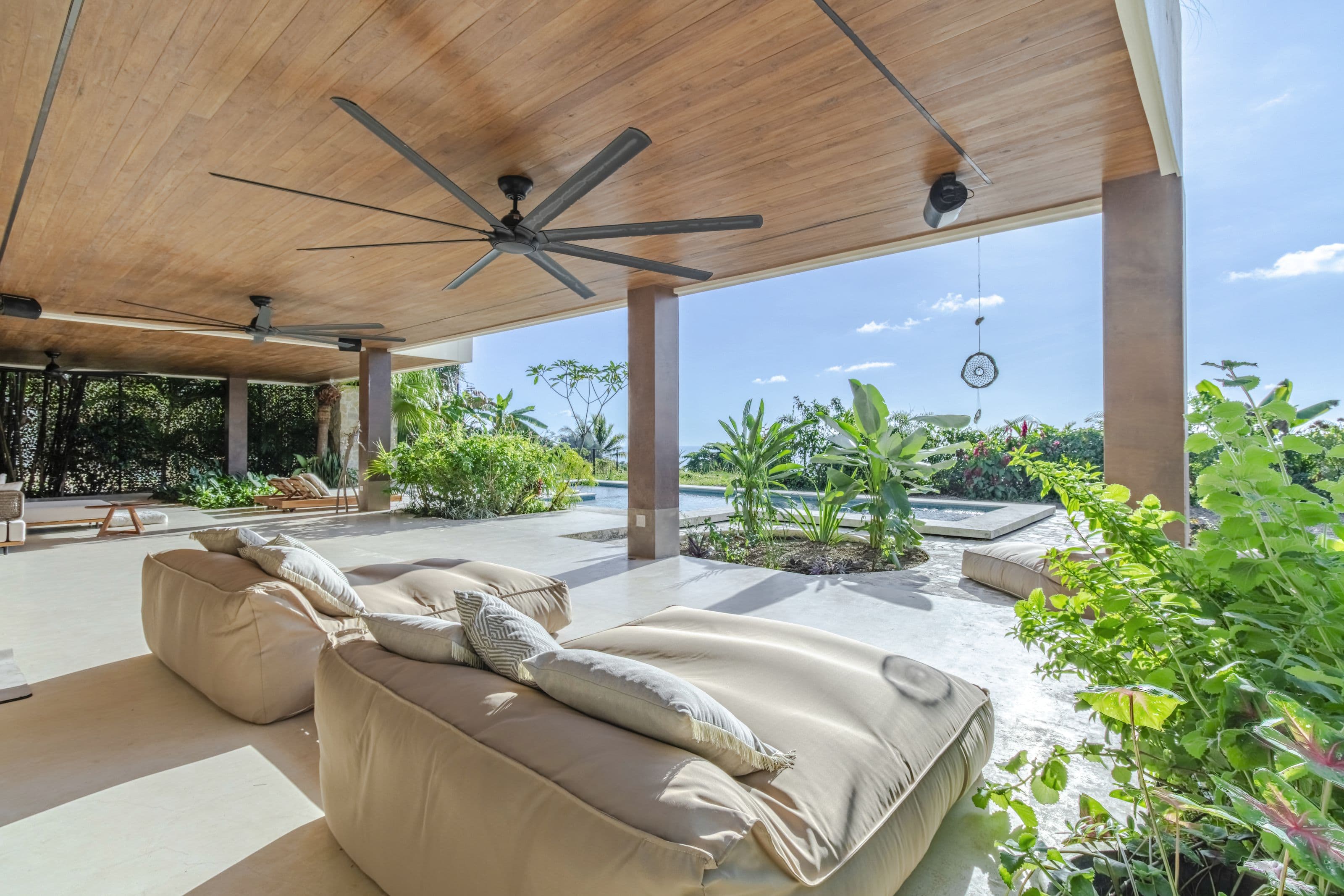 Plush floor loungers on the covered terrace overlooking the pool