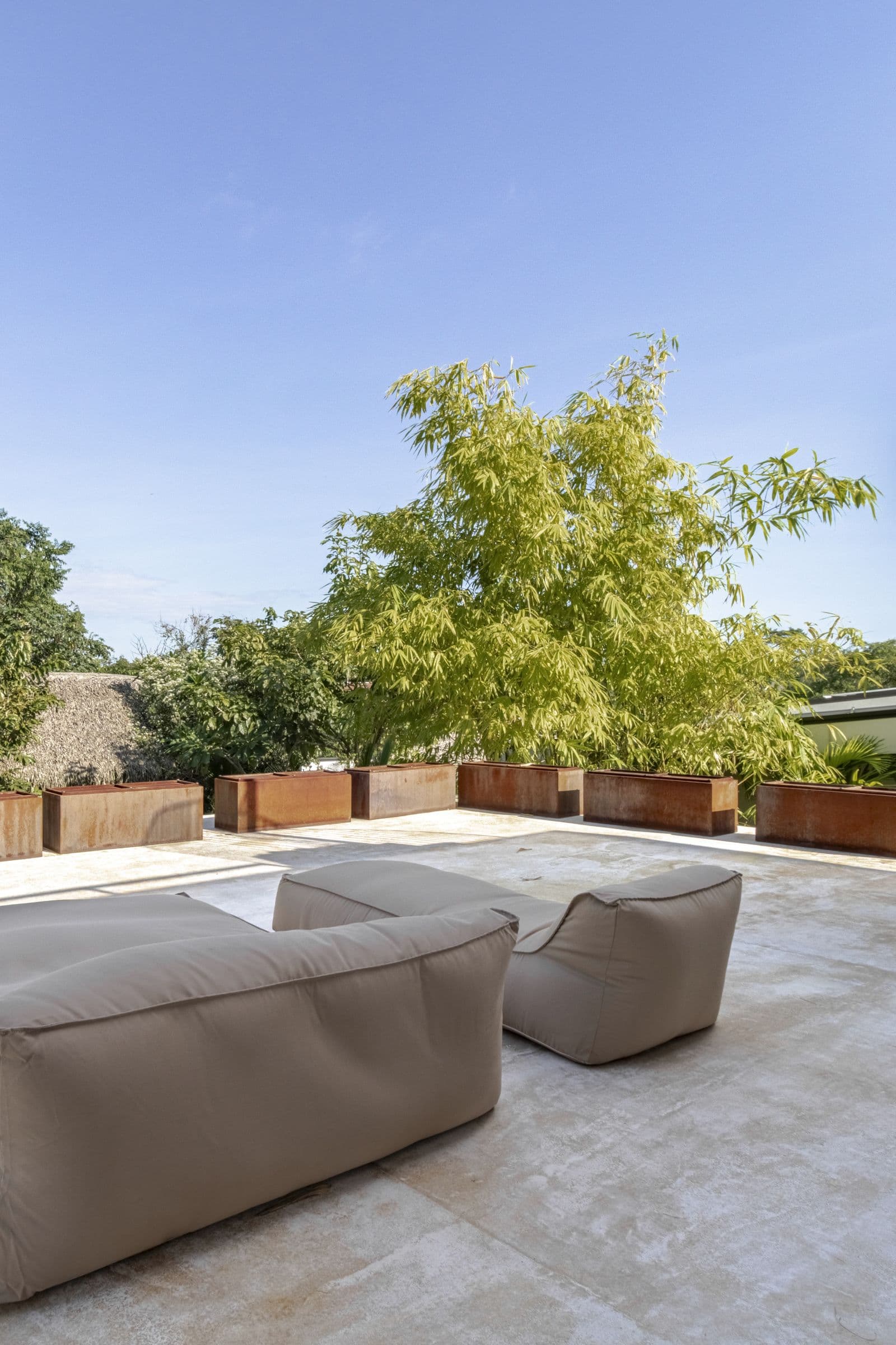 Roof terrace with oversized lounge cushions, planters and a spiral staircase