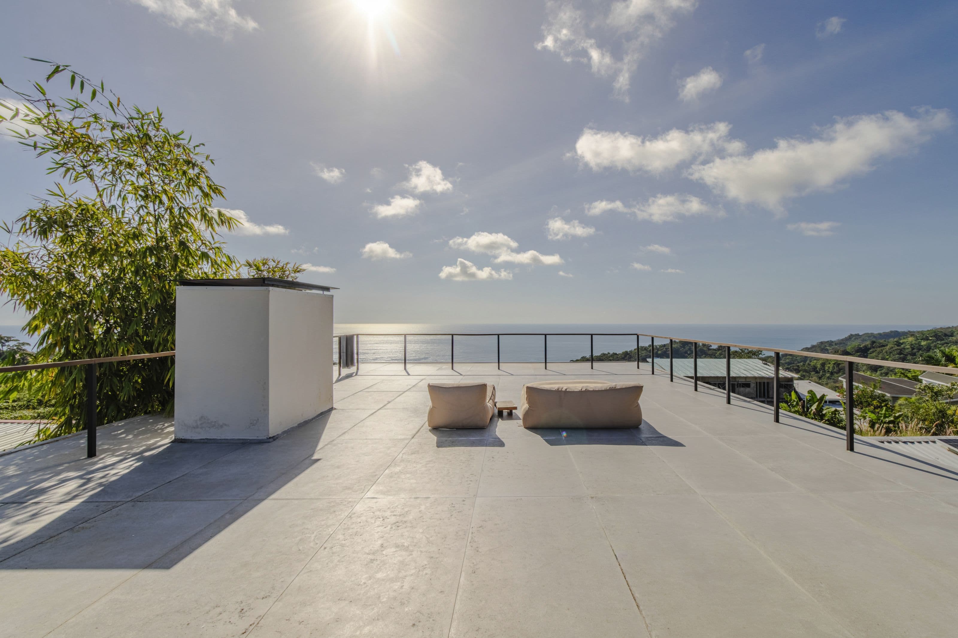 Rooftop deck with lounge cushions and a panoramic view of the Pacific Ocean