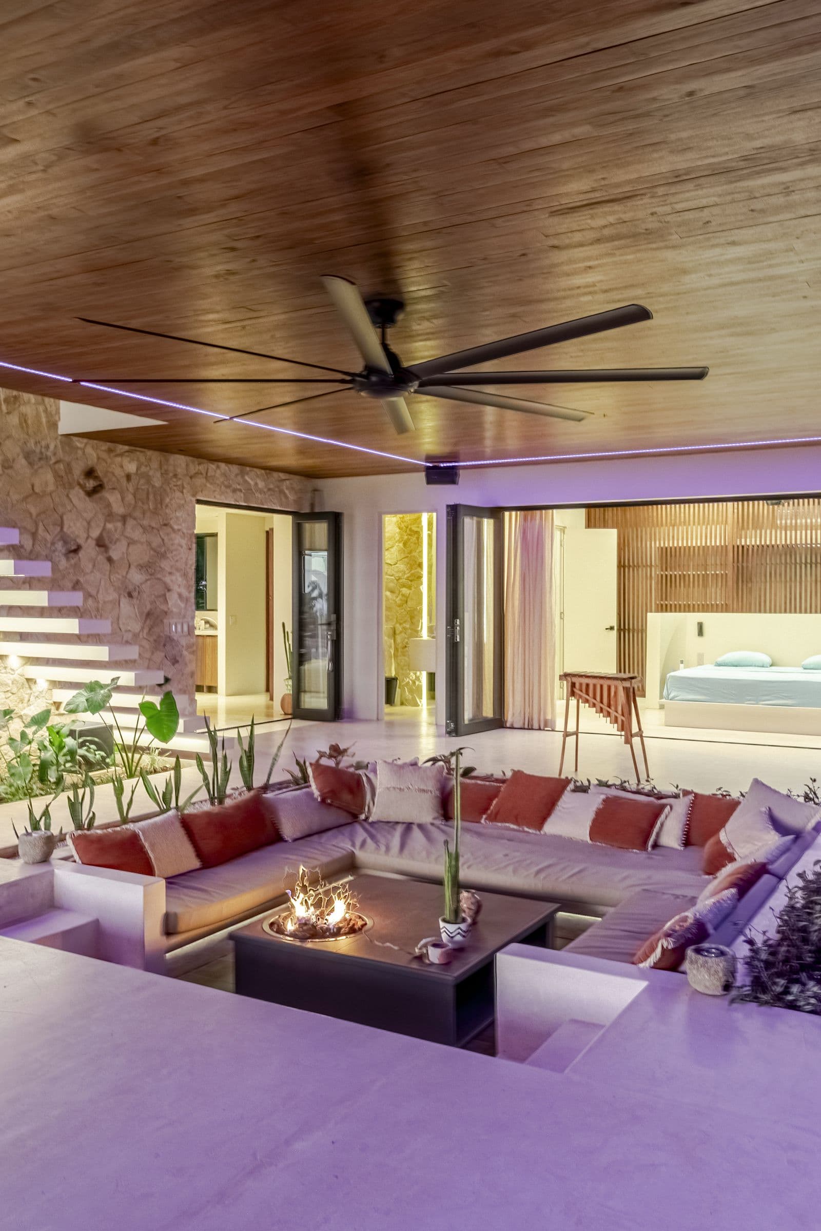 Sunken lounge in the evening lit by warm and violet accent lighting