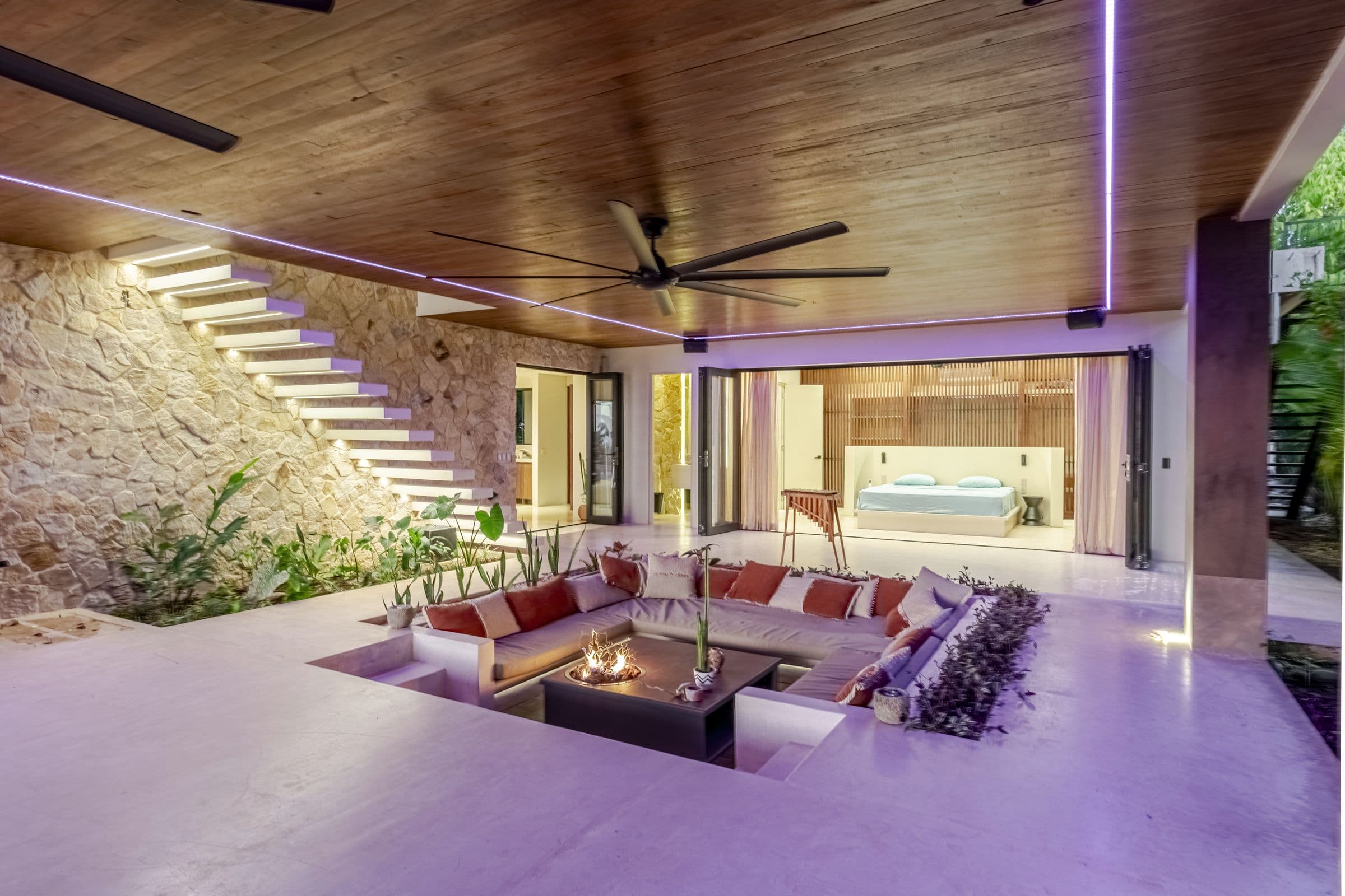 Sunken lounge in the evening lit by warm and violet accent lighting