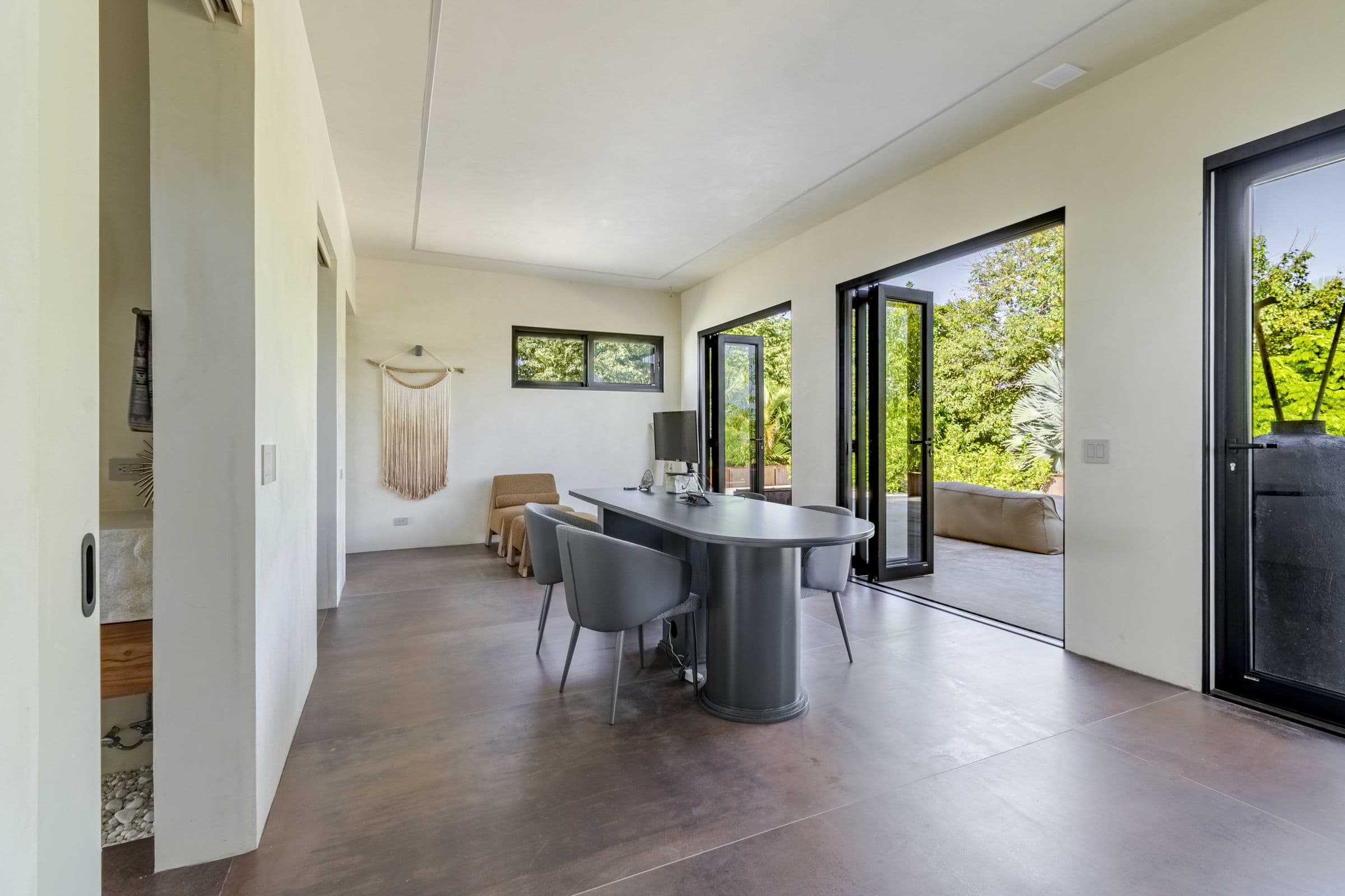 Upstairs dedicated workspace with a desk, chairs and glass doors to the terrace