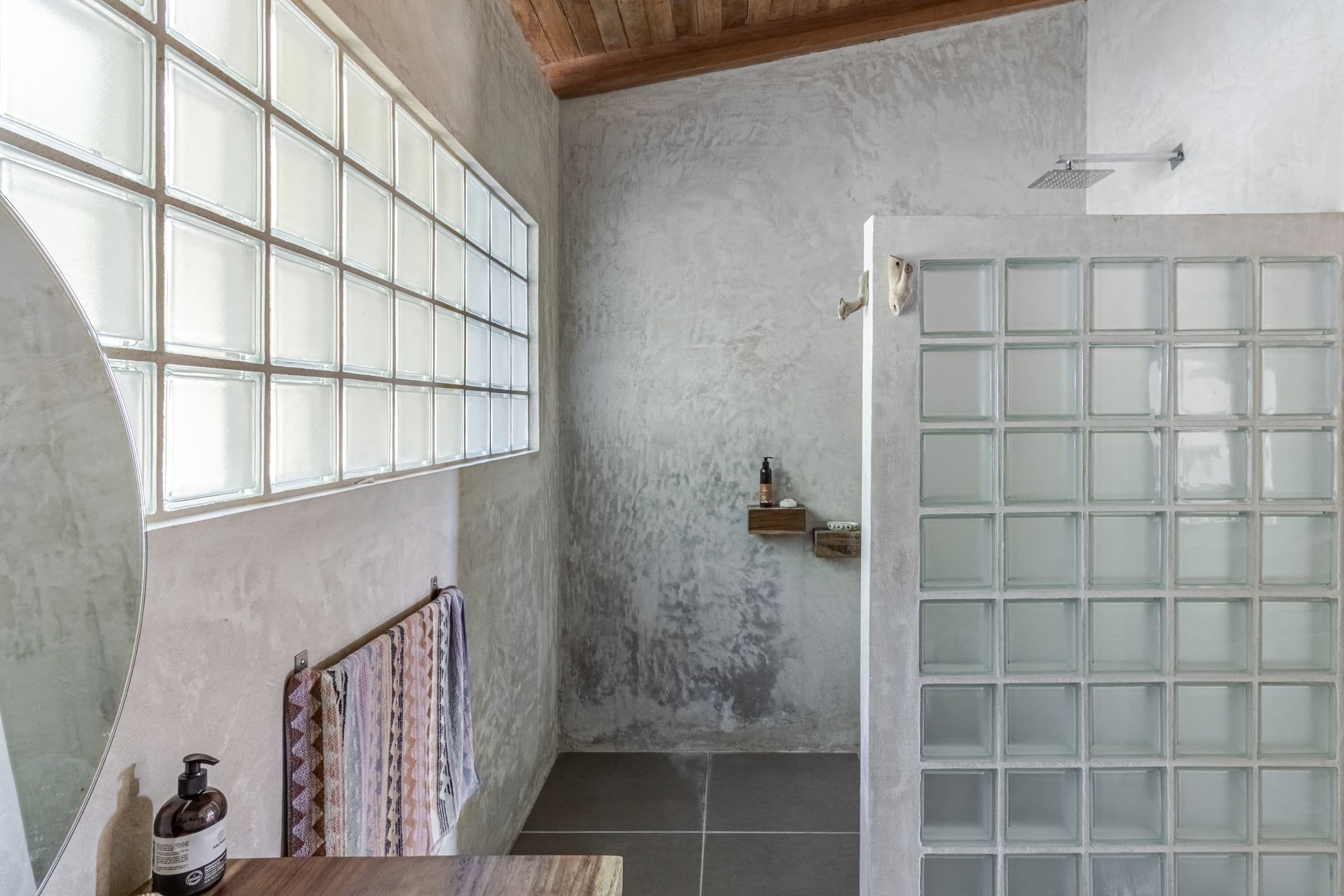 Walk-in rain shower behind a glass-block screen, beneath a glass-block window